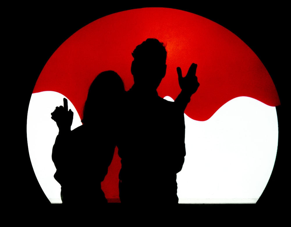a man and a woman standing in front of a red sun