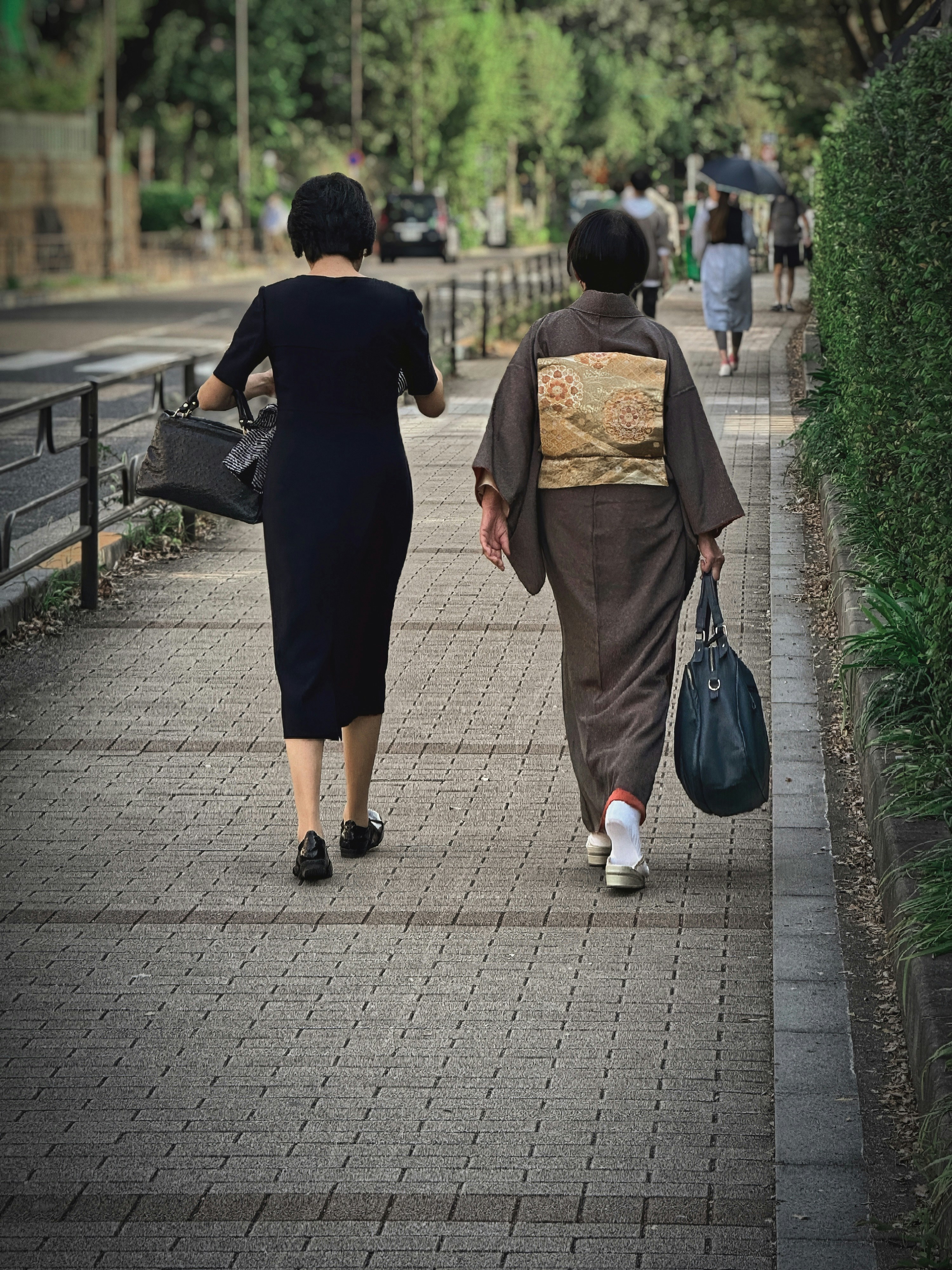 a couple of women walking down a sidewalk