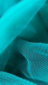 Waves of turquoise mesh fabric create an intricate and layered texture. The mesh features a repetitive hexagonal pattern, giving a sense of depth and dimensionality. The fabric is arranged in soft folds and curves, allowing light to play gently across its surface.