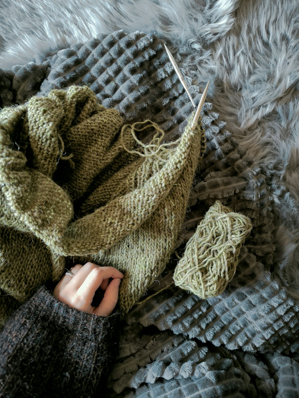 a knitted sweater and a pair of knitting needles