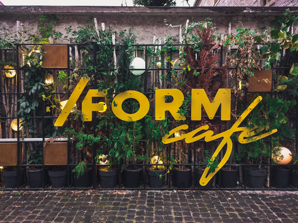 a sign that says form cafe in front of a fence