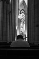 A serene moment of personal prayer and reflection in a quiet chapel space.