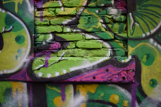 A colorful mural painting in progress, showing brushstrokes and lively textures on a large wall.