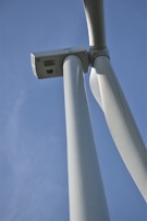 Close-up of a wind turbine blade with blue sky in the background.