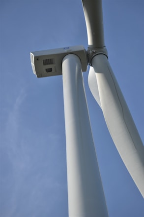 Wind turbine technician inspecting a blade on a sunny day.