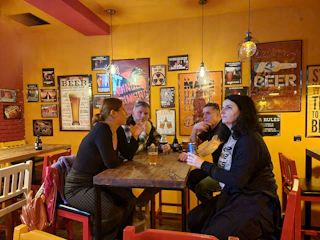 Cozy bar setting with people laughing and playing word games around a table.