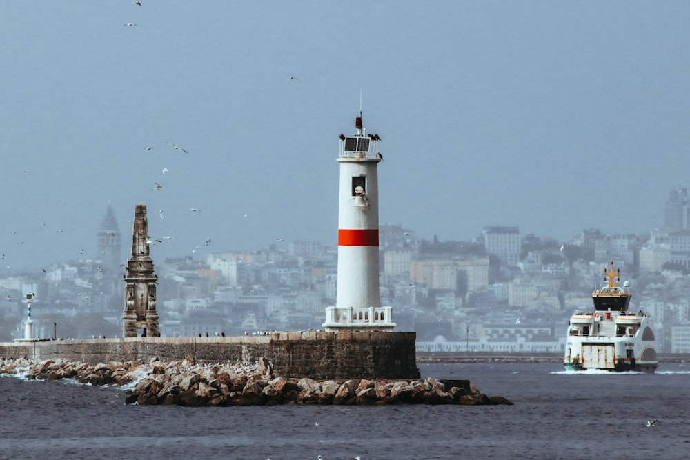 a boat is in the water near a light house