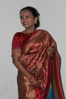 A candid shot of a customer smiling while trying on a saree in a cozy boutique setting.