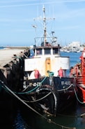 A fishing vessel at sea equipped with satellite communication antennas under a clear sky.