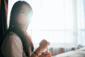A serene image of a person gently applying hair treatment in soft natural light.