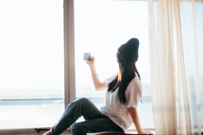 A student practicing portrait photography with natural window light indoors