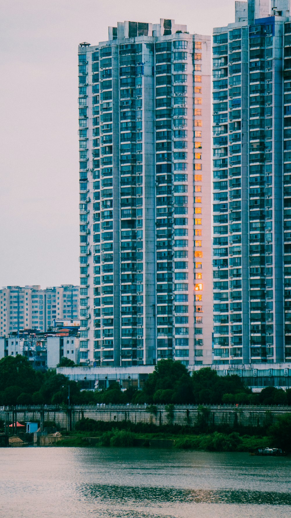 a couple of tall buildings next to a body of water