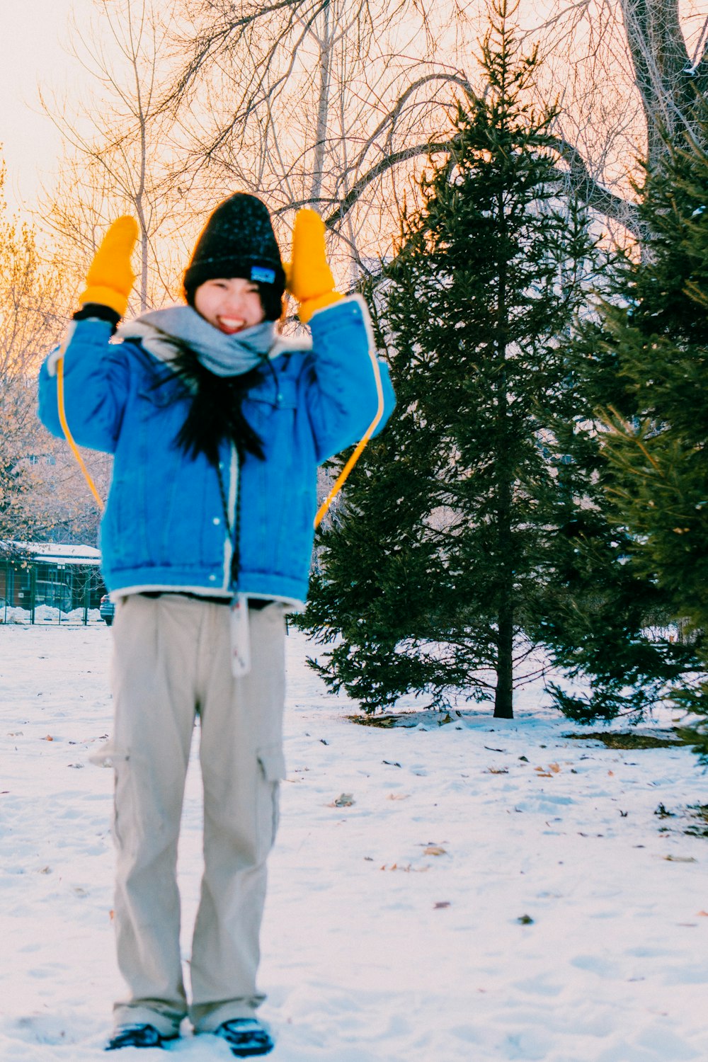 a person standing in the snow wearing a blue jacket