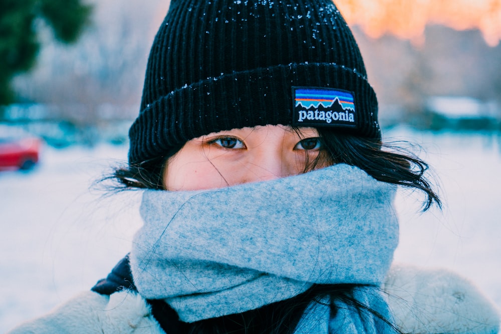 a woman wearing a hat and scarf in the snow