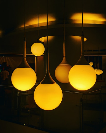 A cozy living room softly illuminated by elegant pendant lights from Vitor Hugo Pimentel Nascimento's collection.