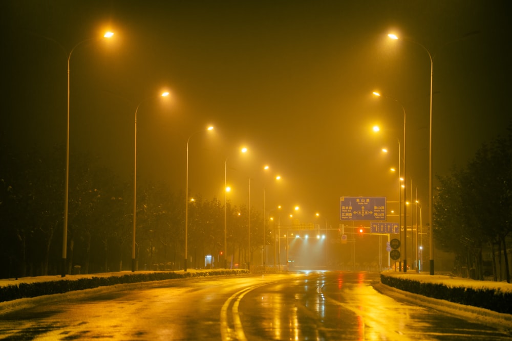 a foggy street at night with street lights