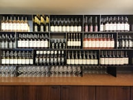 A modern wine cabinet with glass doors showcasing a curated collection of bottles and glasses.