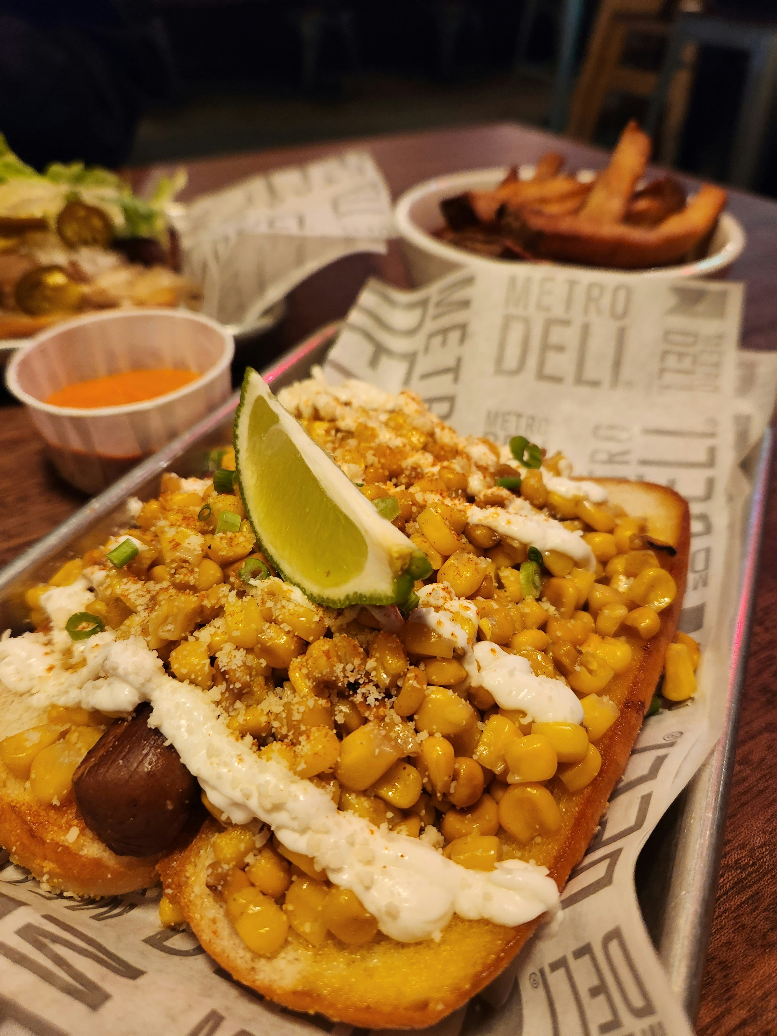 A plant-based hotdog with fresh greens and avocado.