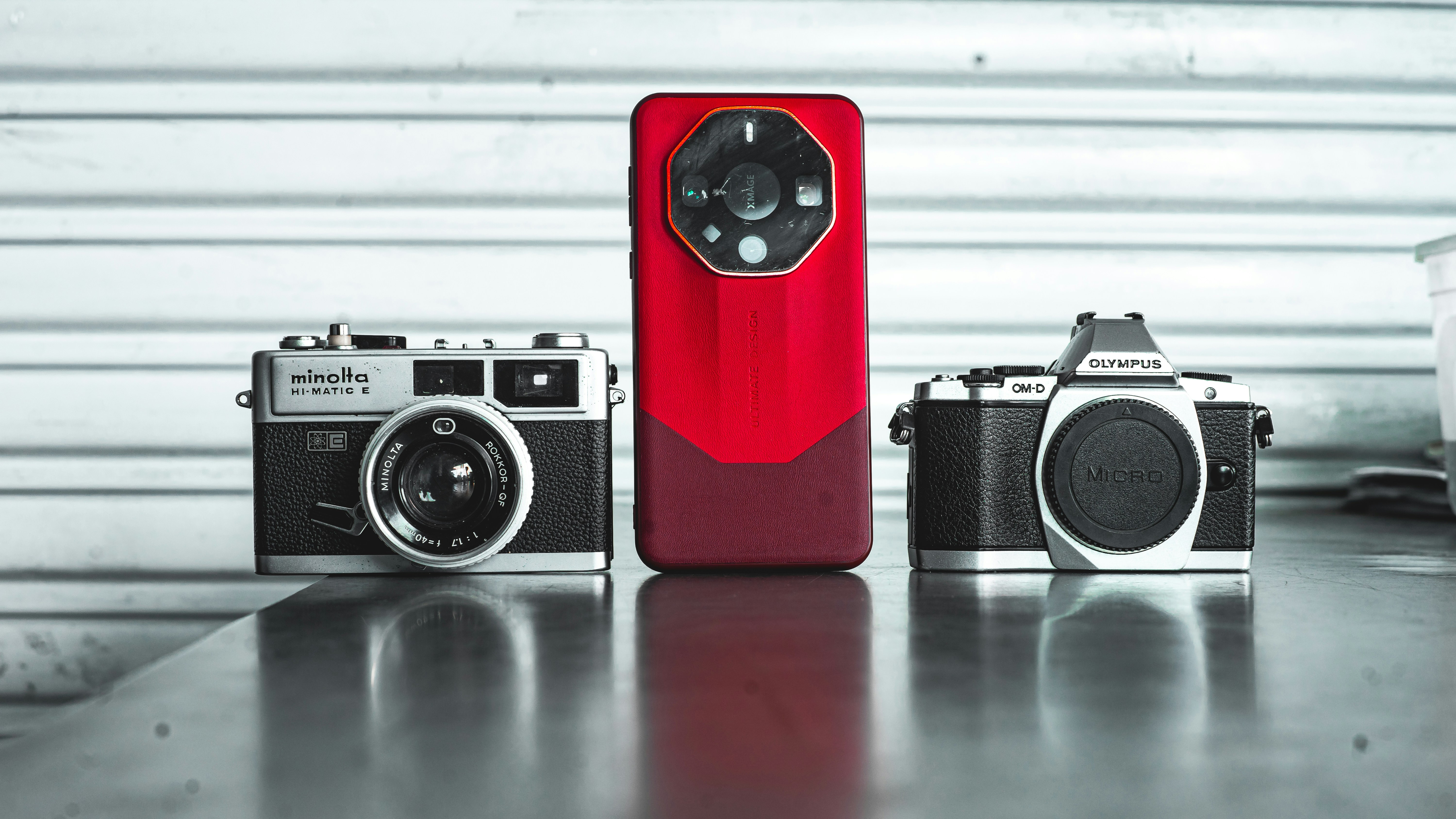 two cameras and a red case sitting on a table