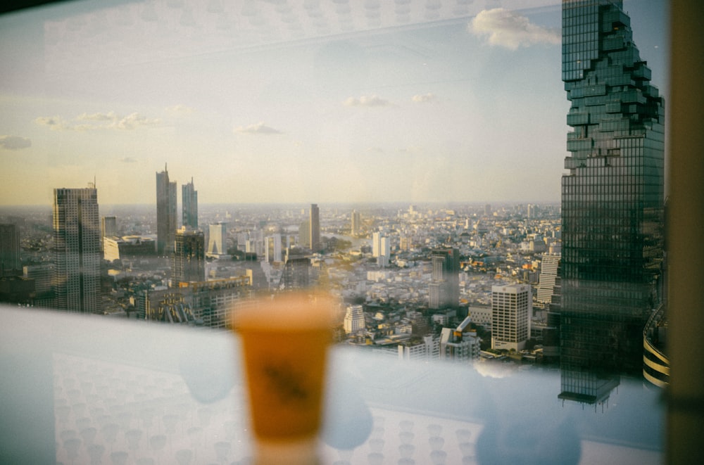 a cup of coffee sitting on top of a table next to a window