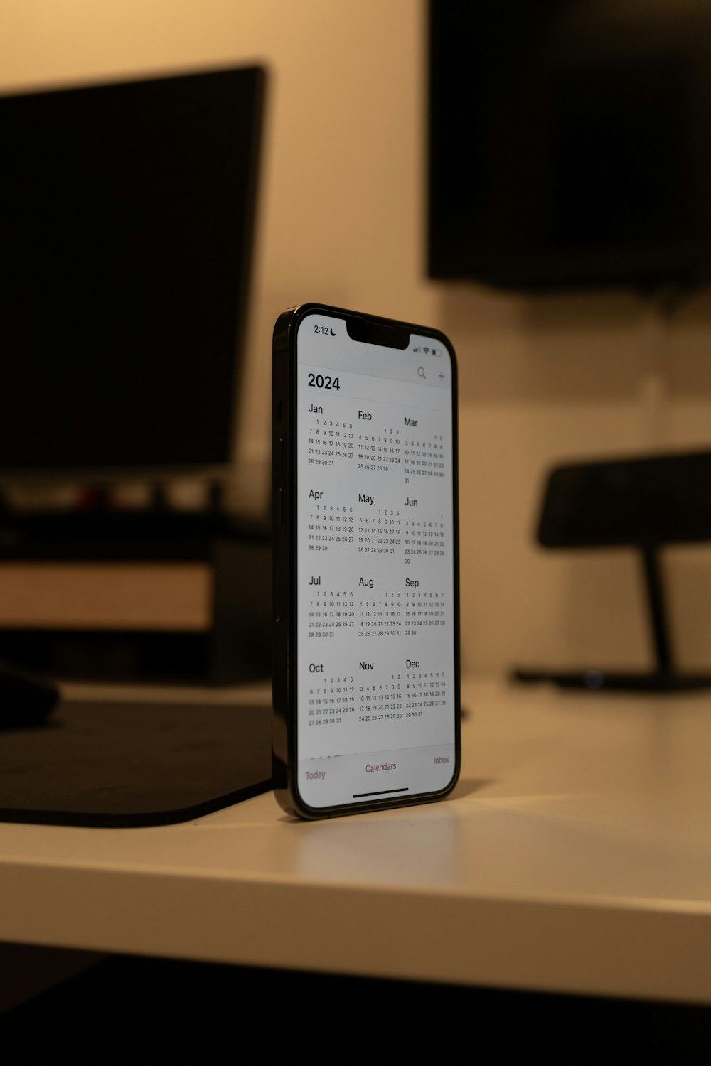 a phone sitting on top of a desk next to a monitor