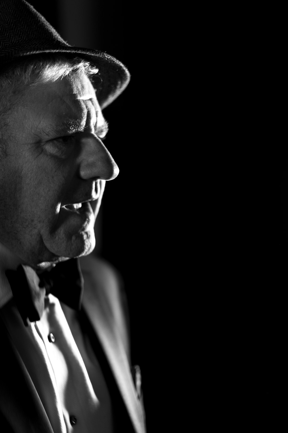 a black and white photo of a man in a suit and hat