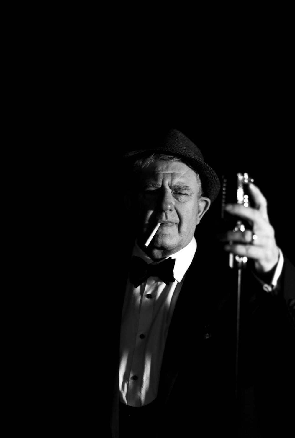 a man in a tuxedo smoking a cigarette