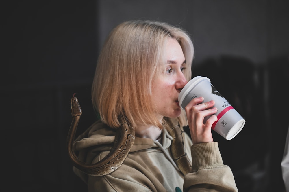 a woman drinking from a coffee cup