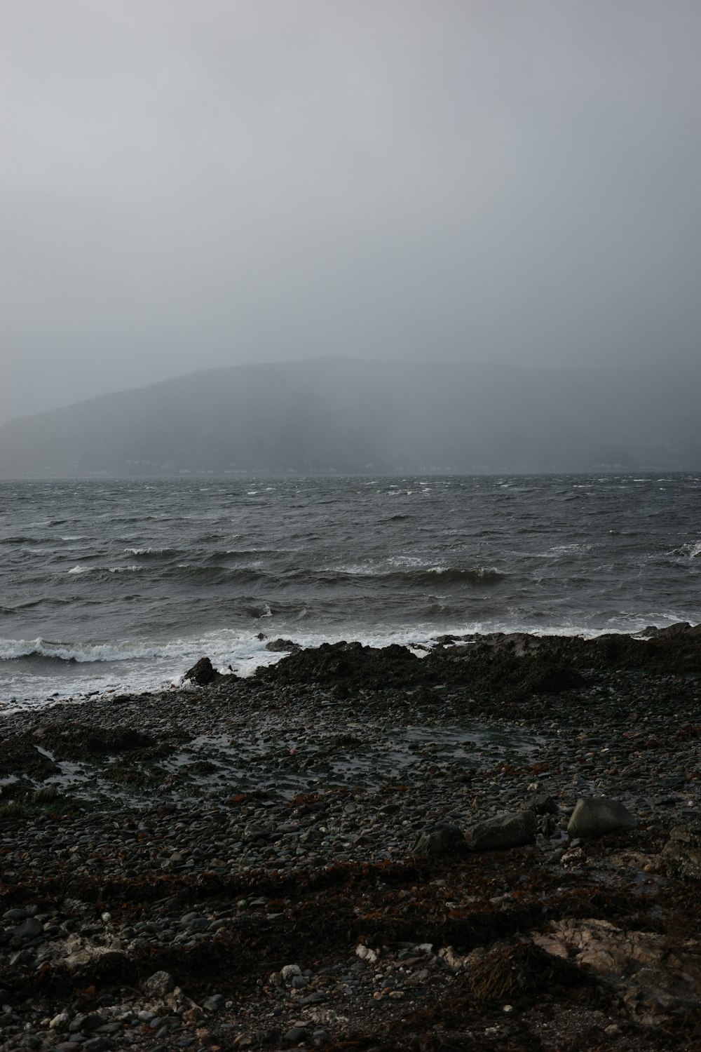 a large body of water sitting on top of a rocky beach