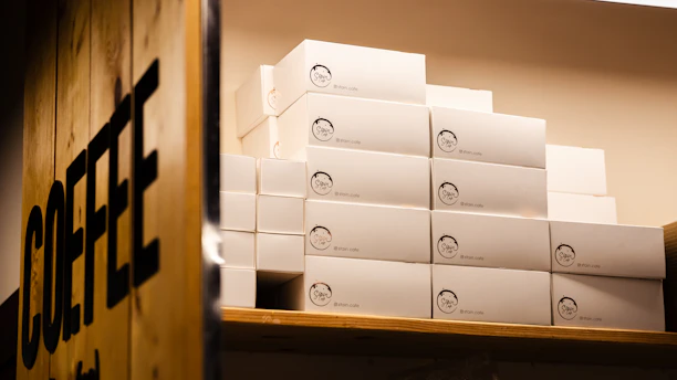 Stack of custom-printed snack boxes featuring vibrant logos and colors on a café counter.