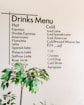 a table with a plant and a menu on the wall