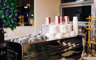 A cozy cafe counter with various colorful drink cups neatly arranged.