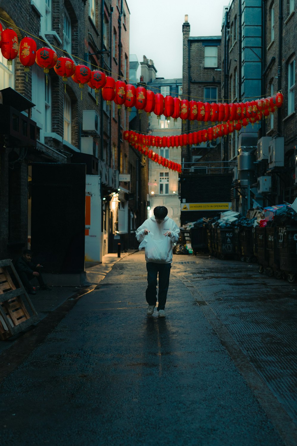 a person walking down a street with red decorations