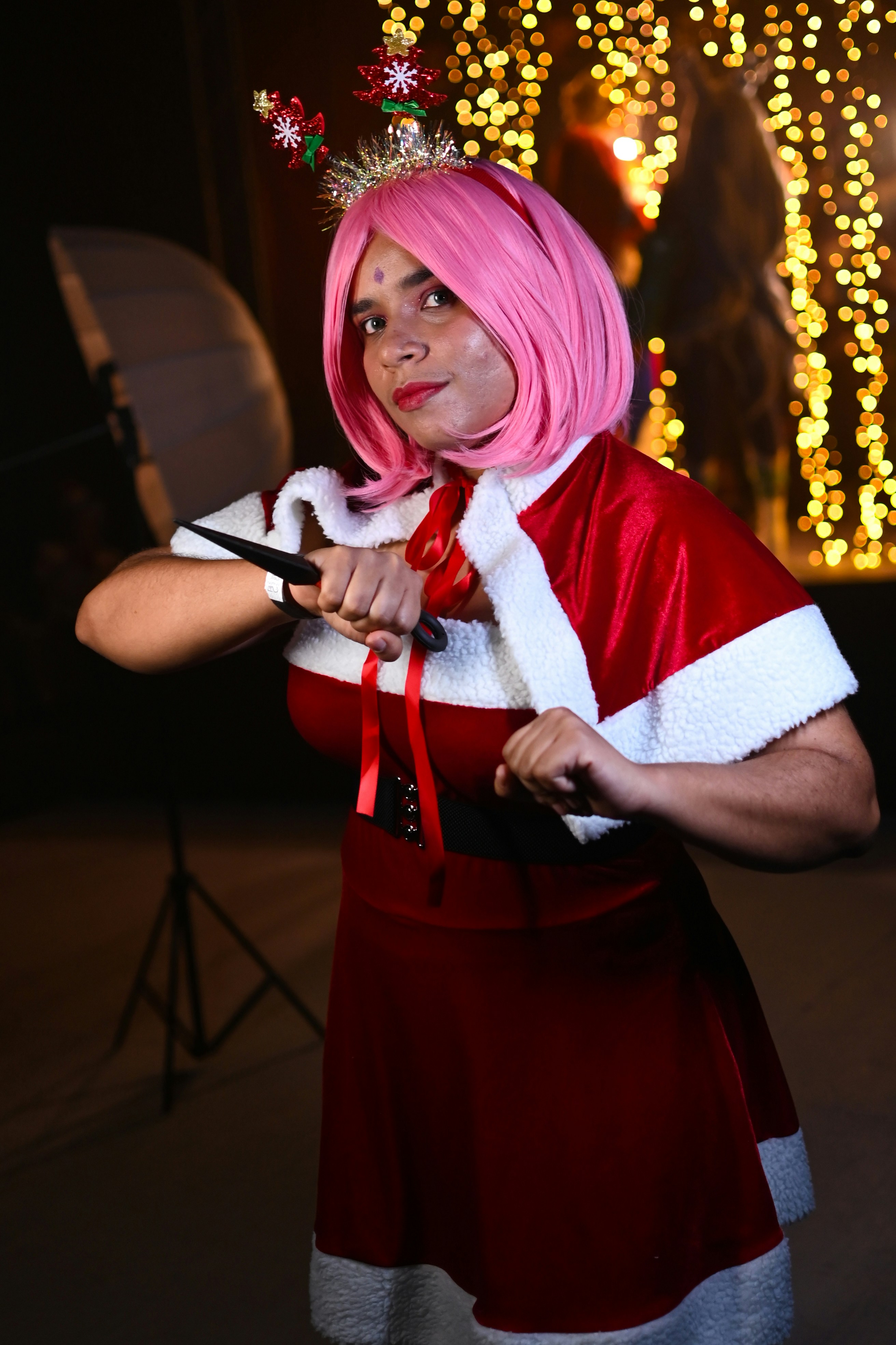 a woman dressed as santa clause holding a pair of scissors