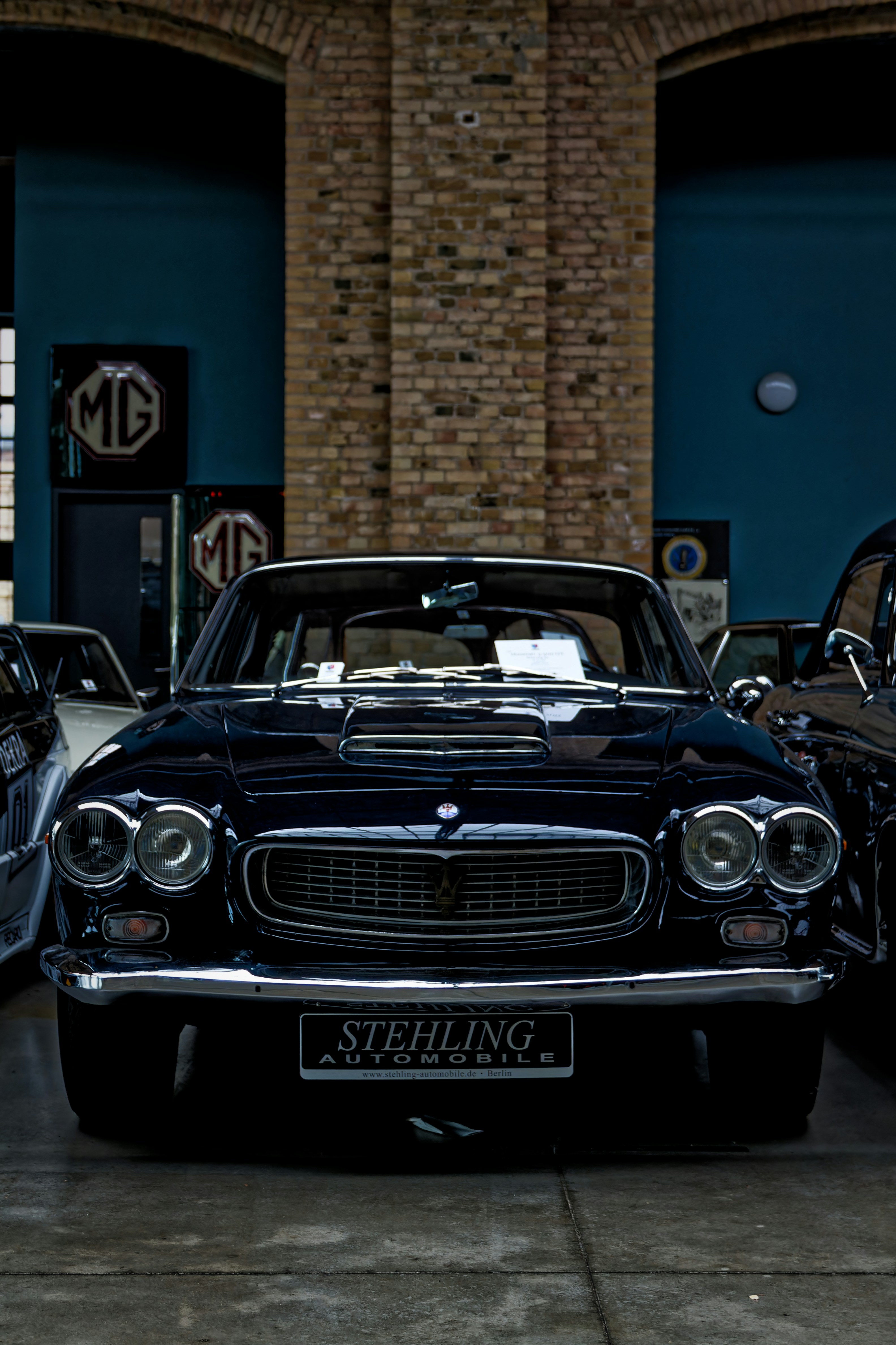 a black car parked in a garage next to other cars