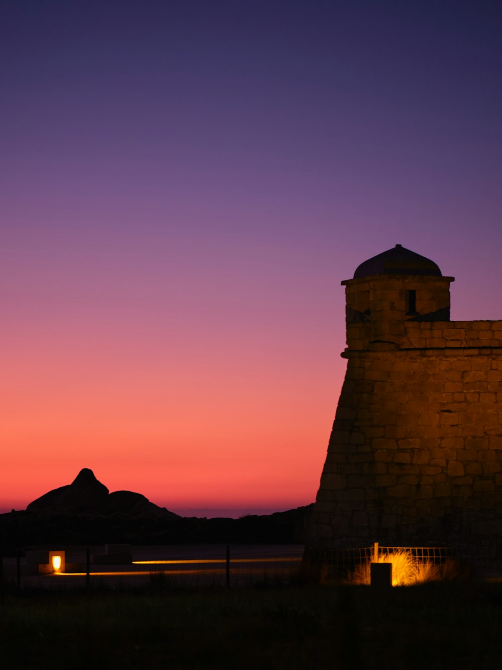 Un edificio con una torre del reloj al atardecer