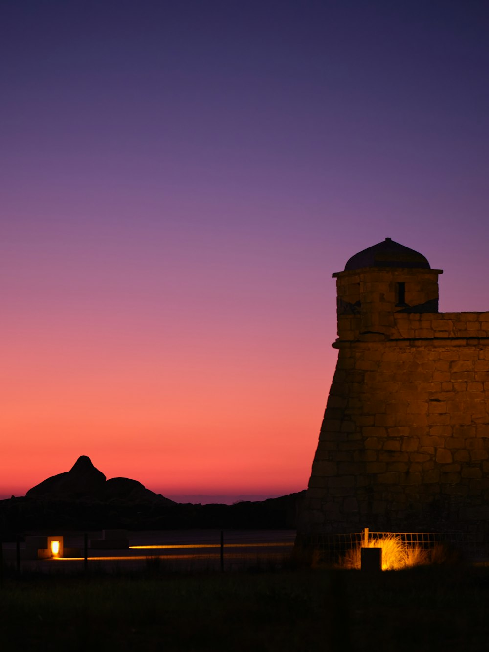 ein Gebäude mit einem Glockenturm bei Sonnenuntergang