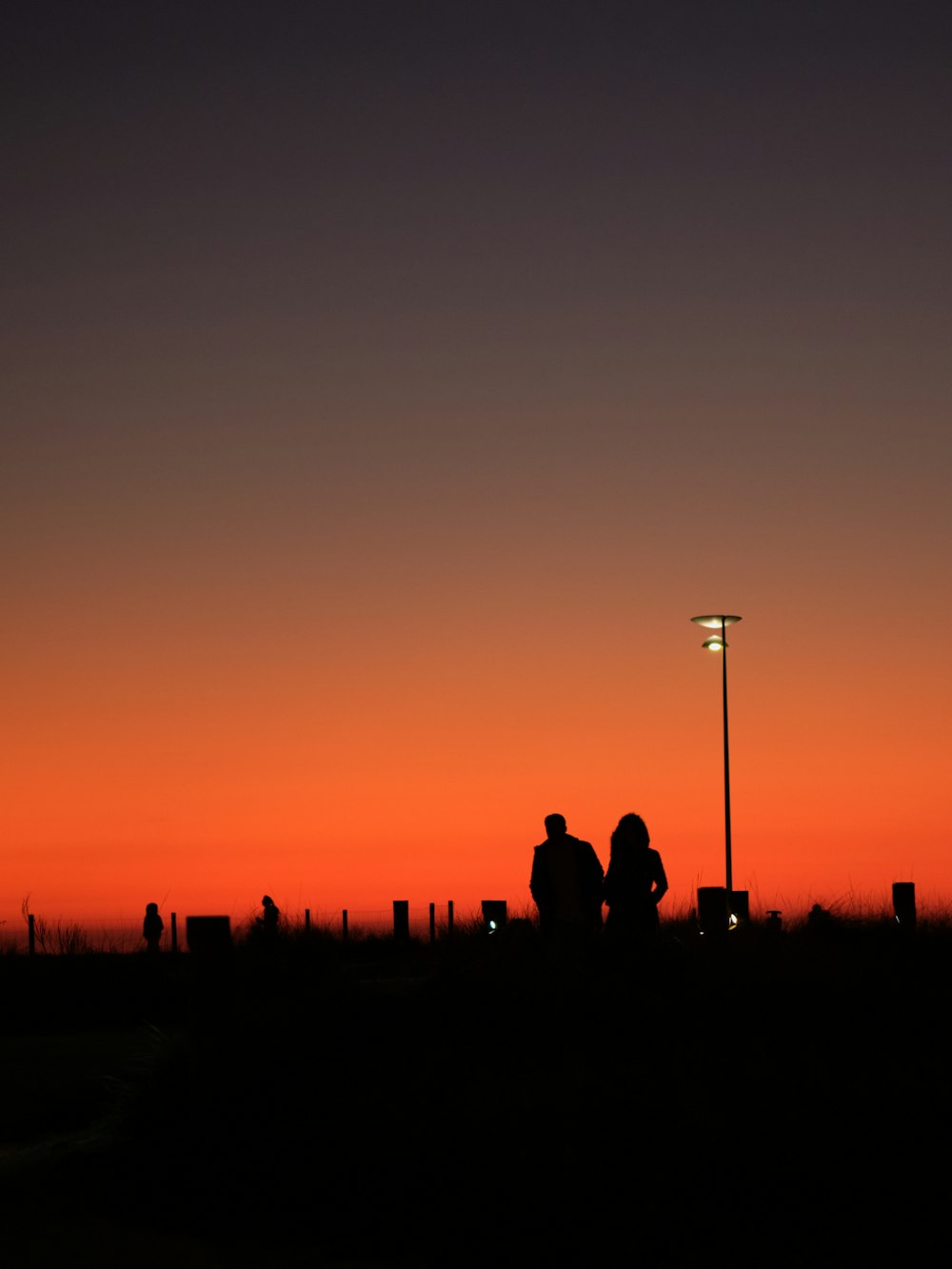 a couple of people standing under a street light