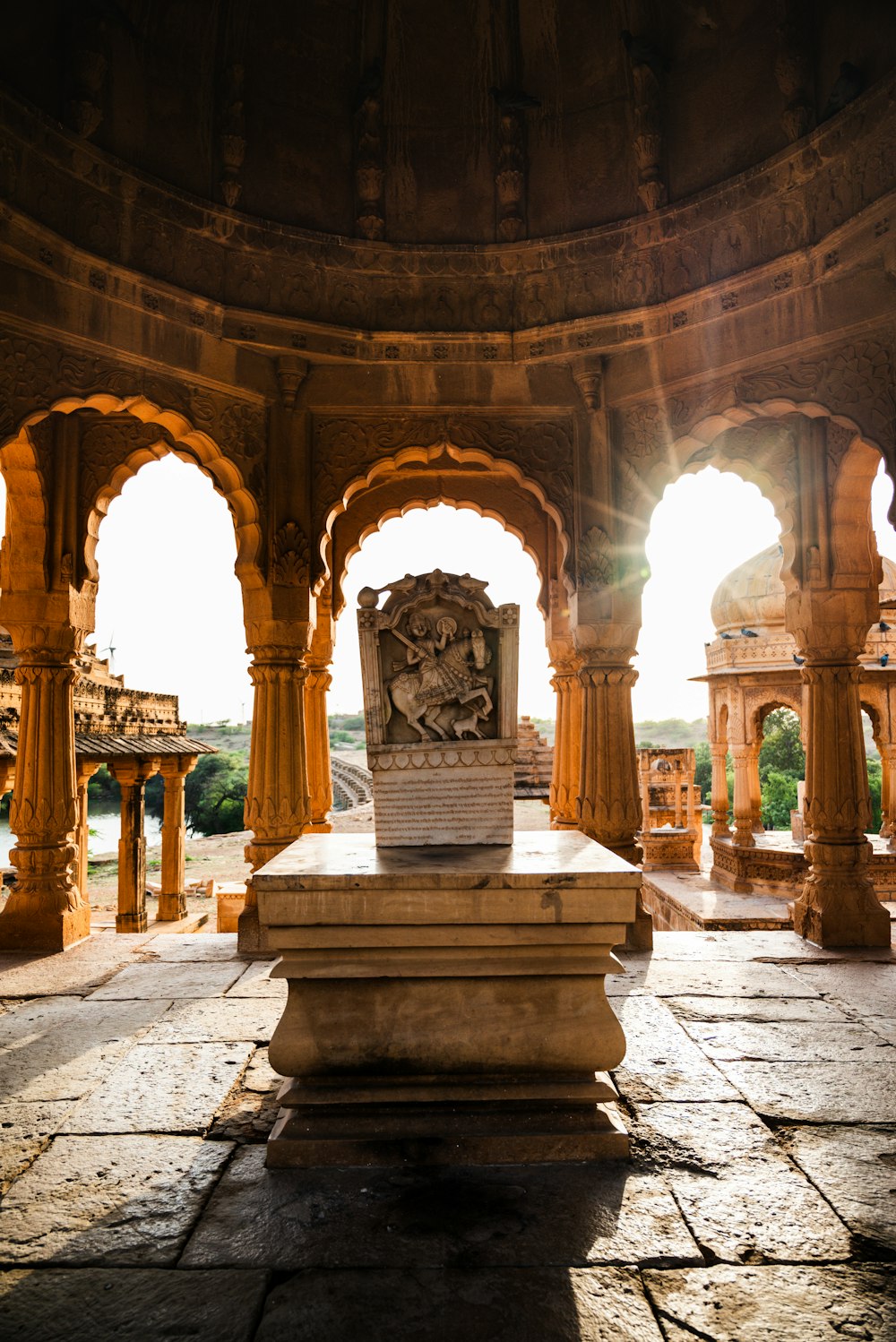 a statue in the middle of a room with arches