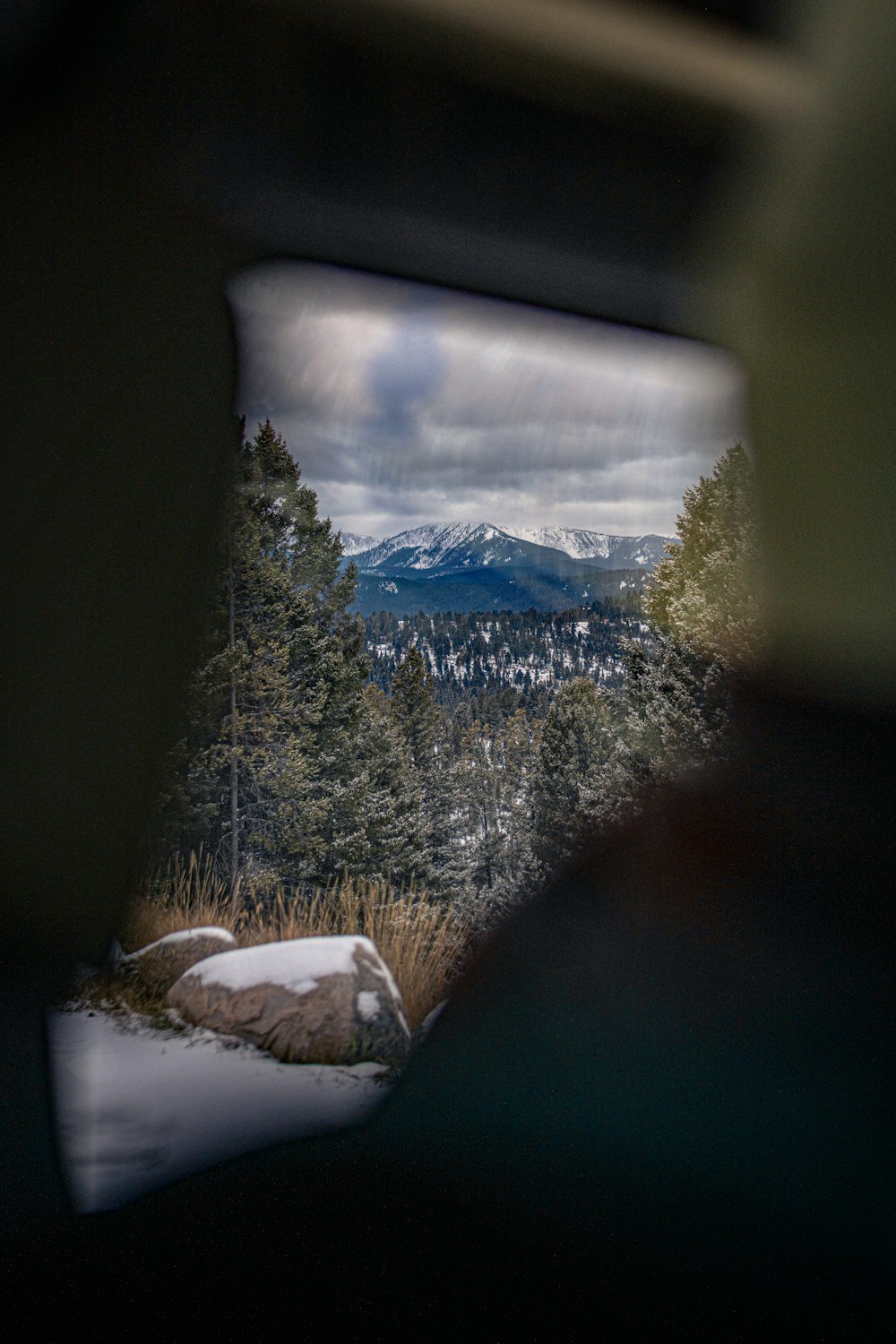 a view of a snowy mountain through a car window