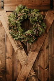 a christmas wreath on a wooden door