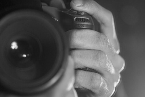 Close-up of weathered hands holding an old camera, highlighting texture.