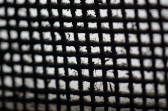 Close-up of a pleated air conditioning filter showing fine mesh fibers.