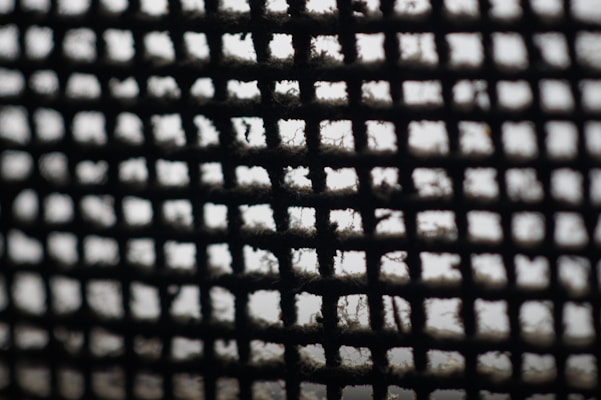 Close-up of a pleated air conditioning filter showing fine mesh fibers.
