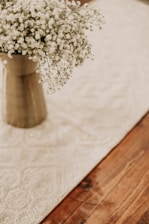 A serene floral arrangement displayed on a wooden table in a bright, airy space.