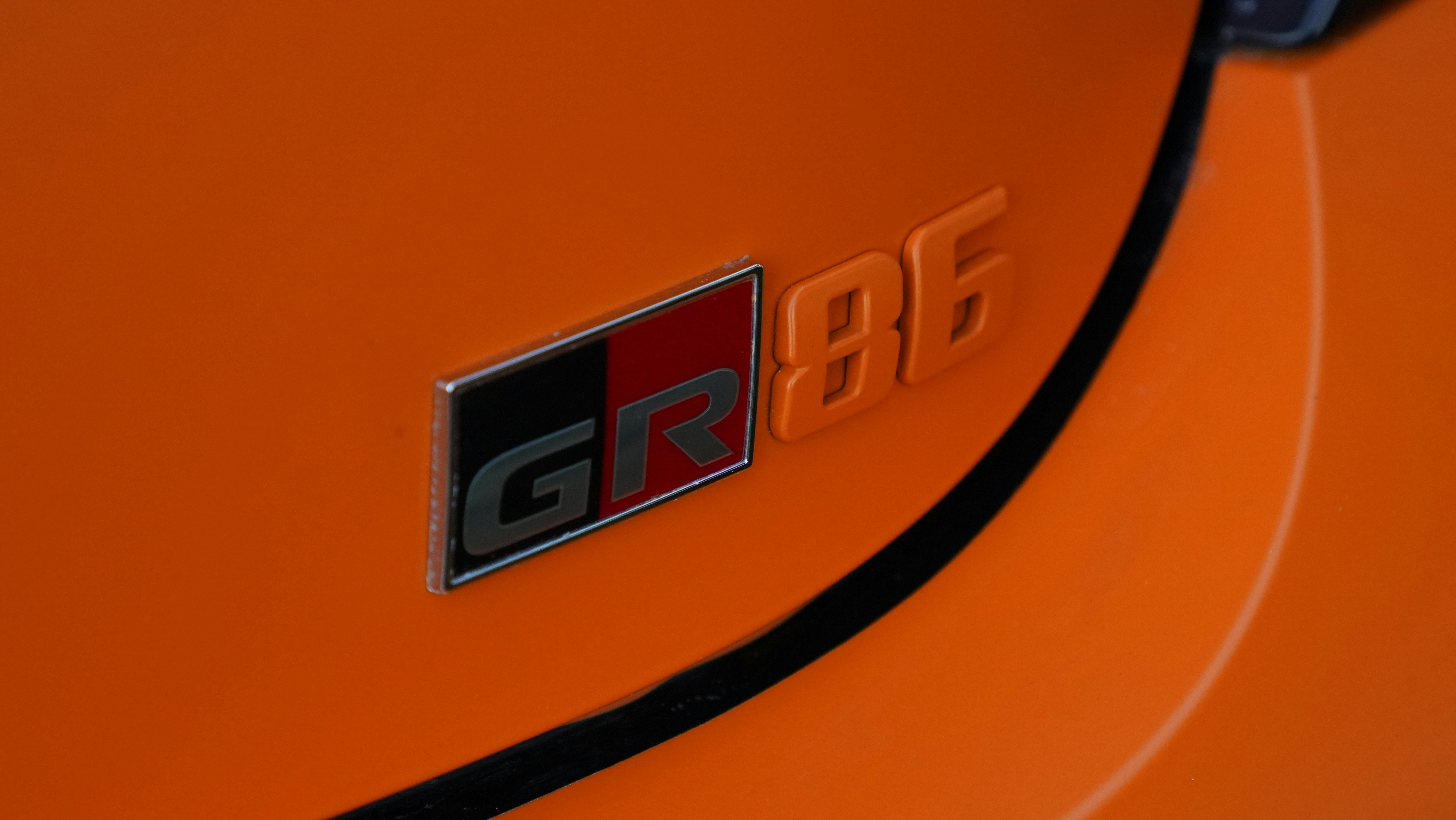 a close up of the emblem on an orange sports car