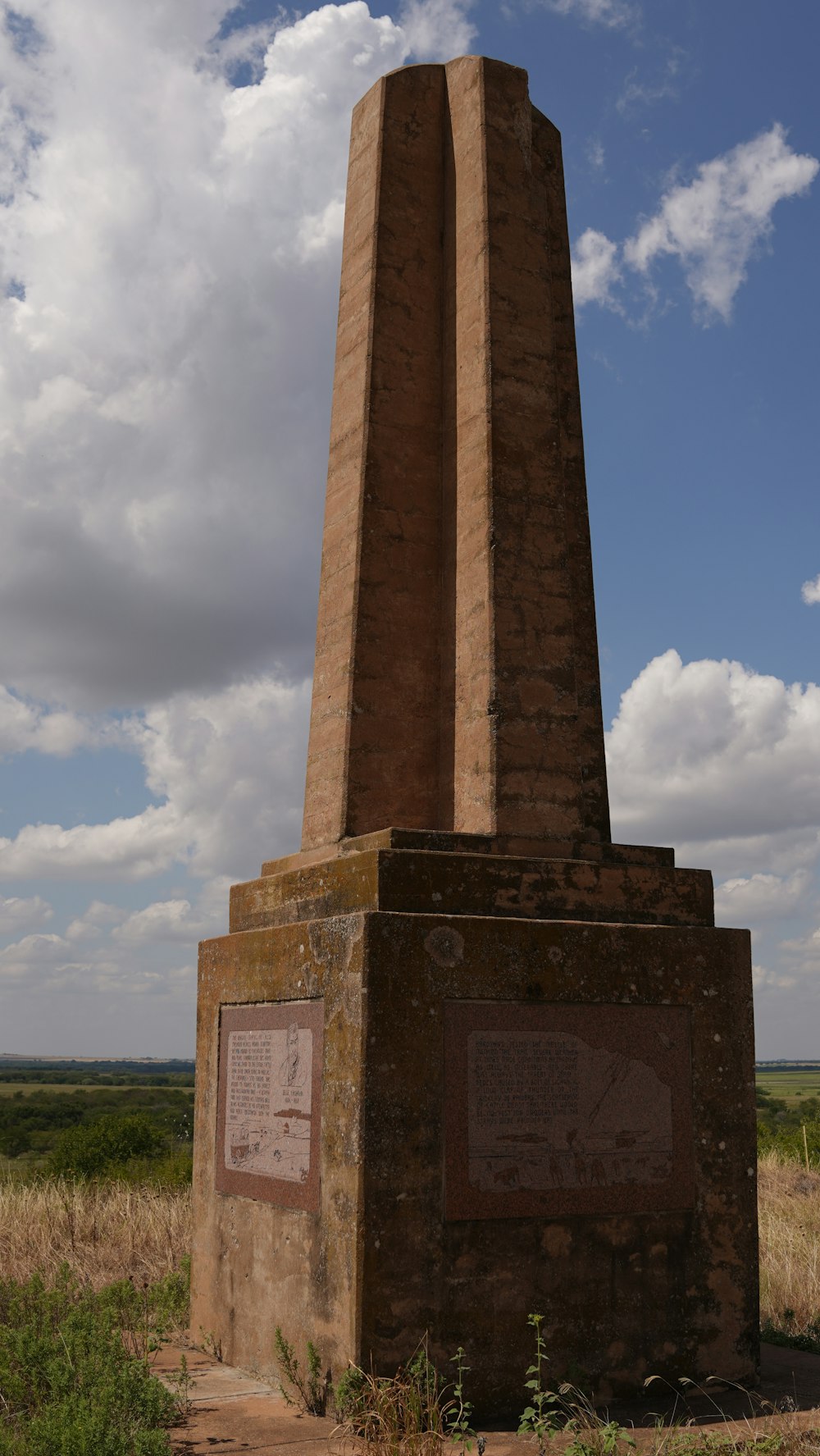 a monument in a field with a sky background