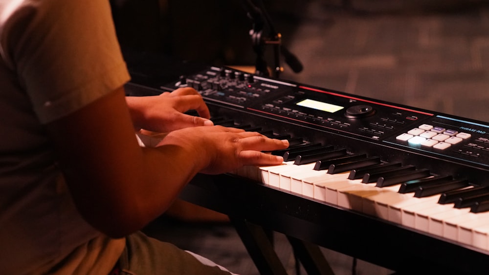 a person sitting at a keyboard with their hands on it