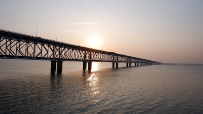 Wide shot of a long bridge spanning a deep valley during golden hour.