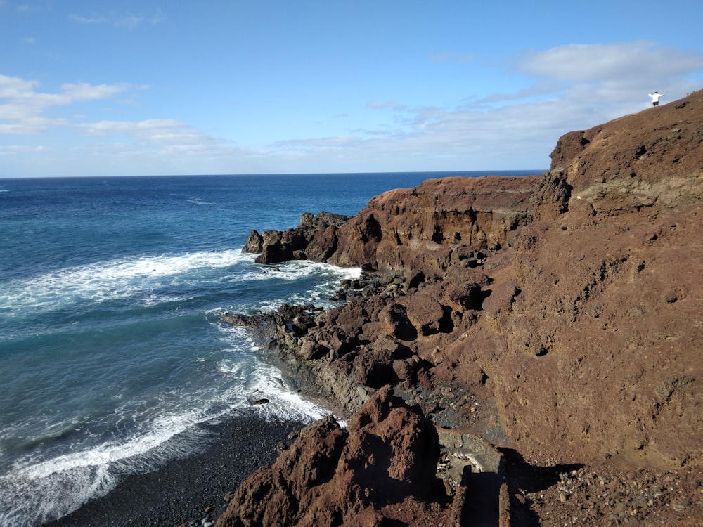 a view of the ocean from a rocky cliff